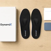 ערכת DynamiX על שולחן עץ: קופסה, זוג מדרסים, כרטיס הוראות ומשטח תרגול